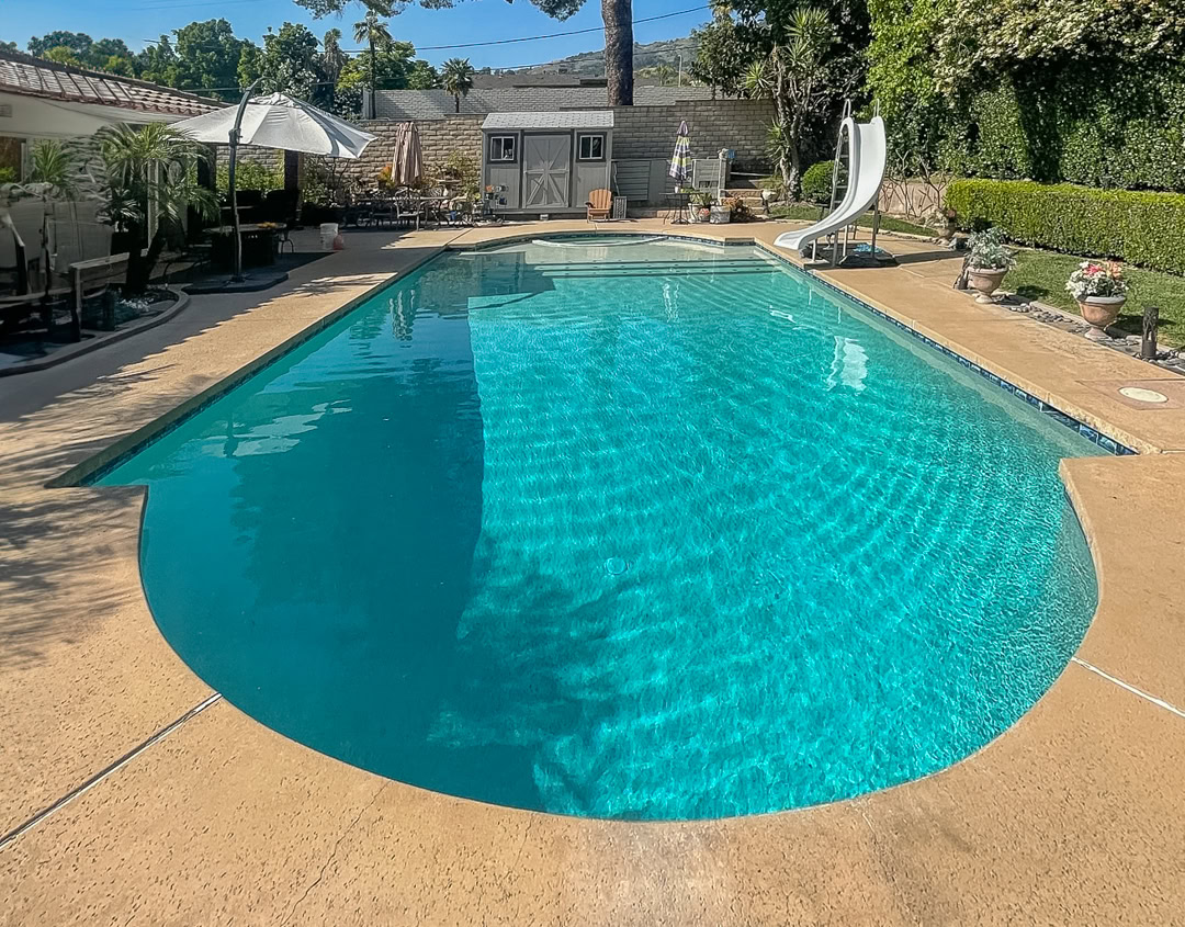 Pool remodel by The Pool Pro. Pebble finish, added sun shelf, new tile.