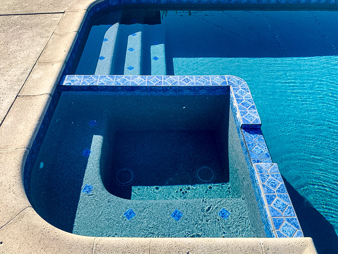 A swimming pool remodel by The Pool Pro. Pebble finish, new tile.